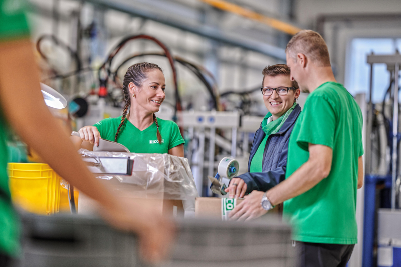 Kollege unterhält sich mit 2 Kolleginnen