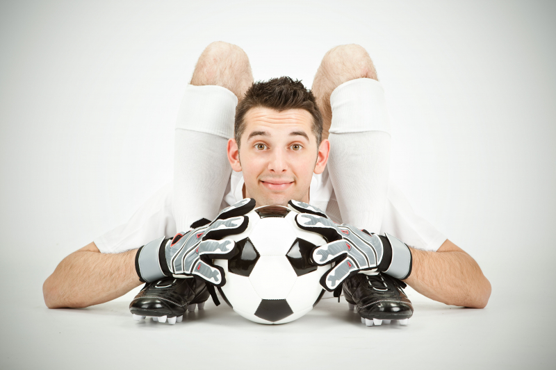 flexibler Mann mit Fußball